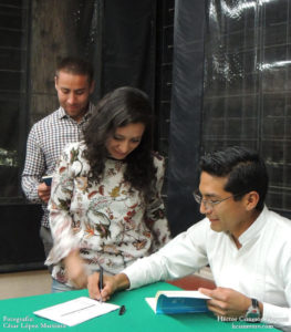 Hector Cisneros firmando libros. Presentación del poemario El agua y las luciernagas en la UACM.