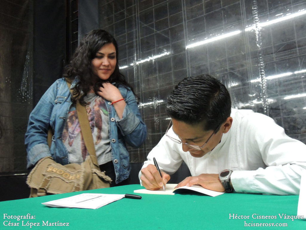 Hector Cisneros firmando libros. Presentación del poemario El agua y las luciernagas en la UACM.